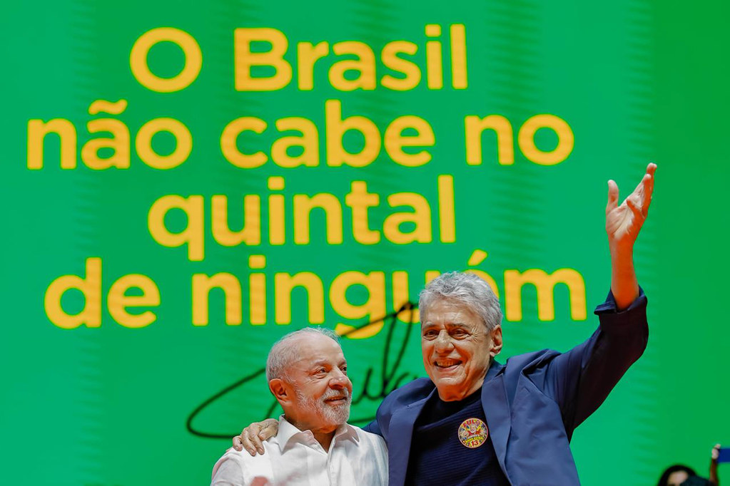 Chico Buarque acena para o público ao lado de Lula no palco da Fundição Progresso
