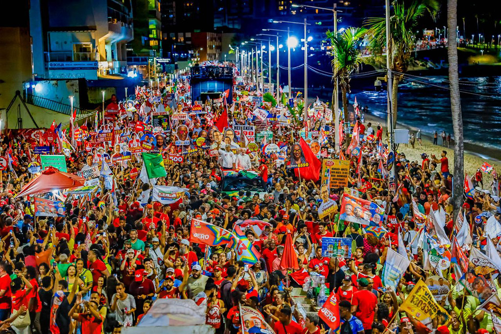 Multidão com bandeiras na orla de Salvador à noite