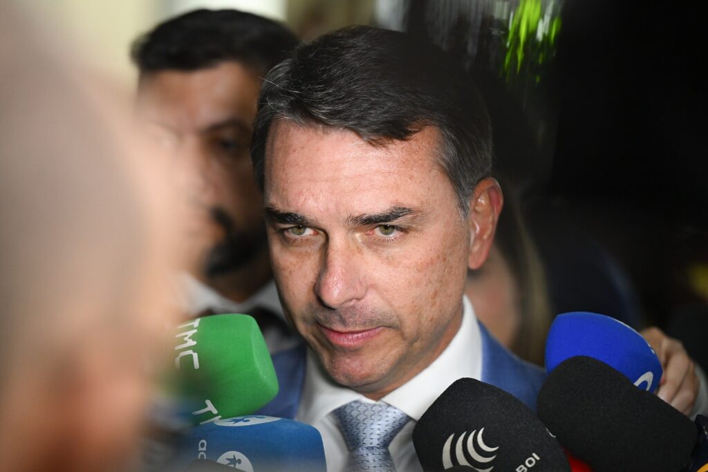 Flávio Bolsonaro cercado de microfones durante entrevista no Senado